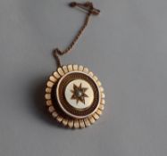 A Victorian yellow metal mourning brooch, of circular form, set to the centre with seed pearls,