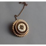 A Victorian yellow metal mourning brooch, of circular form, set to the centre with seed pearls,