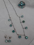 A white metal necklace set with eight topaz drops,
