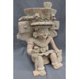 A pre-Columbian type figure, seated in an elaborate head dress with wings, and collar,