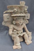 A pre-Columbian type figure, seated in an elaborate head dress with wings, and collar,