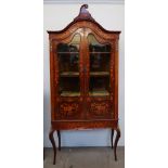 An Edwardian mahogany marquetry decorated display cabinet with a scrolling cornice and domed top