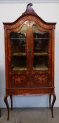 An Edwardian mahogany marquetry decorated display cabinet with a scrolling cornice and domed top