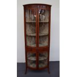 An early 20th century yew wood bow front corner cabinet painted with pseudo flutes,