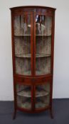 An early 20th century yew wood bow front corner cabinet painted with pseudo flutes,