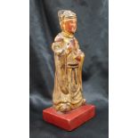 A Chinese carved, gilt and red painted figure of a dignitary on a square base,