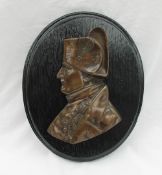 A bronze wall plaque depicting Horatio Nelson in profile, mounted on an ebonised board,