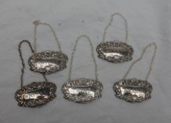 A set of four Elizabeth II silver wine labels, embossed with shells, leaves and scrolls for Whisky,