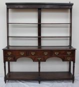 An 18th century South Wales oak dresser, the rack with a moulded cornice above two open shelves,