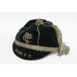 A 19th century sporting cap, in black velvet with white metal braiding and tassel,