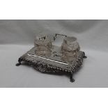 A late Victorian silver desk standish, with a shell leaf and dart border on four claw feet,