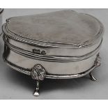 A George V silver trinket box of rounded triangular outline, moulded rim with scroll corners,