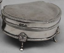 A George V silver trinket box of rounded triangular outline, moulded rim with scroll corners,