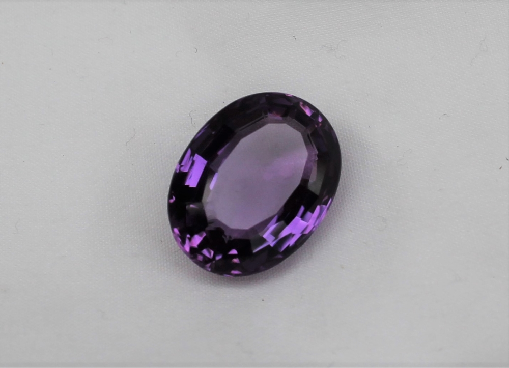 An unmounted amethyst, of oval faceted form, measuring approximately 22mm x...