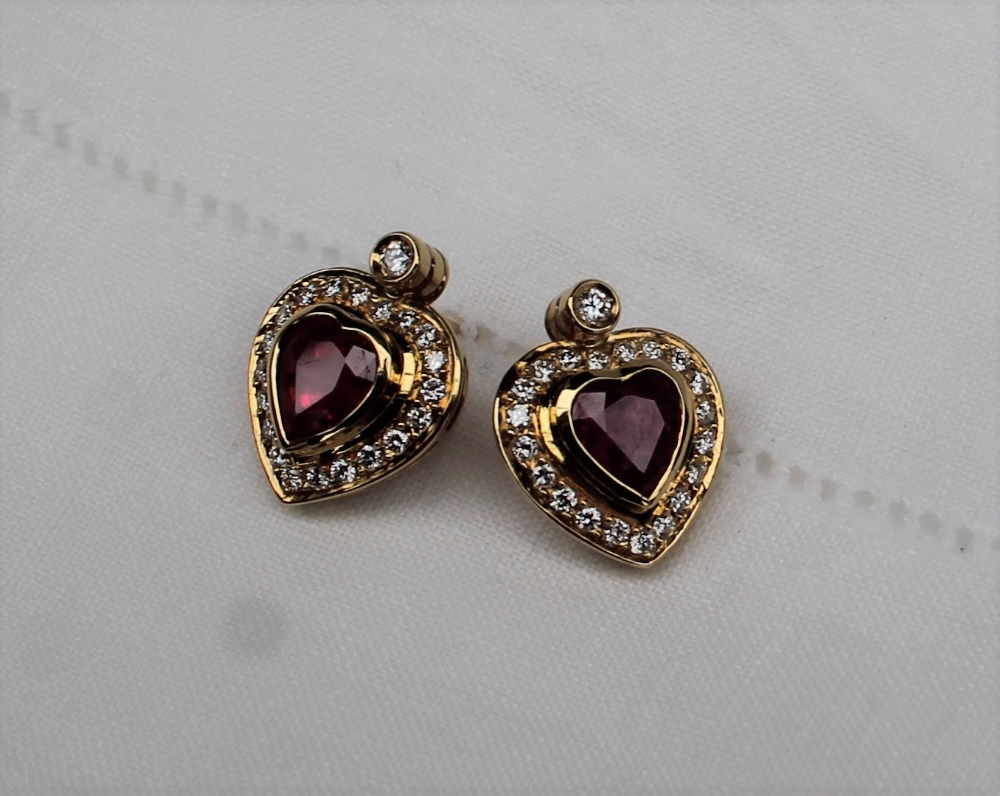 A pair of heart shaped ruby and diamond stud earrings, the central heart shaped ruby,