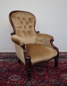 A Victorian walnut framed armchair with spoon shaped back, padded arms and bowed seat,