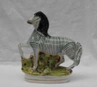 A Staffordshire flat back figure of a zebra on an oval naturalistic base, 22.