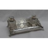 A late Victorian silver desk standish, of rectangular form, with a pierced three quarter gallery,