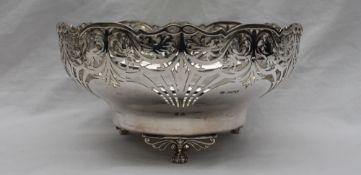 A George VI silver bowl of circular form with a pierced rim and tapering body on pierced lions paw