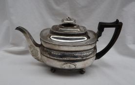 A George III silver teapot of oval shape with a flower and leaf border on ball feet, London, 1810,