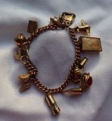 A 9ct yellow gold charm bracelet, set with numerous charms including a shell, tankard,