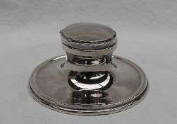 A George V silver desk inkwell of plain round capstan shape, makers Hutton & Sons,