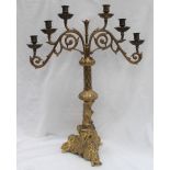 A gilt metal six branch candleabra, with a leaf capped scrolling support,