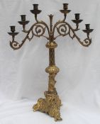 A gilt metal six branch candleabra, with a leaf capped scrolling support,