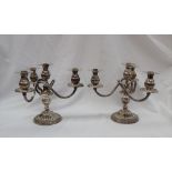 A pair of Camusso Peruvian white metal three branch candelabra,