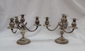 A pair of Camusso Peruvian white metal three branch candelabra,