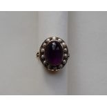 A 9ct yellow gold dress ring, with a cabochon amethyst surrounded by pearls, size P,