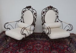 A pair of wrought iron elbow chairs, of wirework form,