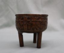 A Japanese bronze koro, cast to the rim with dogs of foo, on three legs,