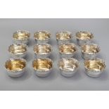 A SET OF TWELVE .833 STD PORTUGUESE SILVER DESSERT BOWLS, wavy borders decorated with shell and leaf