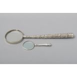 AN INDIAN SILVER HANDLE MAGNIFYING GLASS, the entire handle profusely embossed with figures,