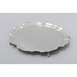 A SILVERPLATED SALVER, of circular form with moulded curvilinear pie-crust rim, standing on four