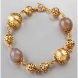 AN 18ct YELLOW GOLD AND AGATE BRACELET, composed of two agate beads, two large gold balls and six