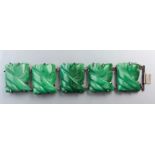 A VINTAGE SILVER AND GREEN JADE BRACELET, composed of five carved jade plaques inter-locked with