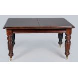 AN EDWARDIAN MAHOGANY EXTENDING DINING TABLE, the double-moulded top above a frieze housing an