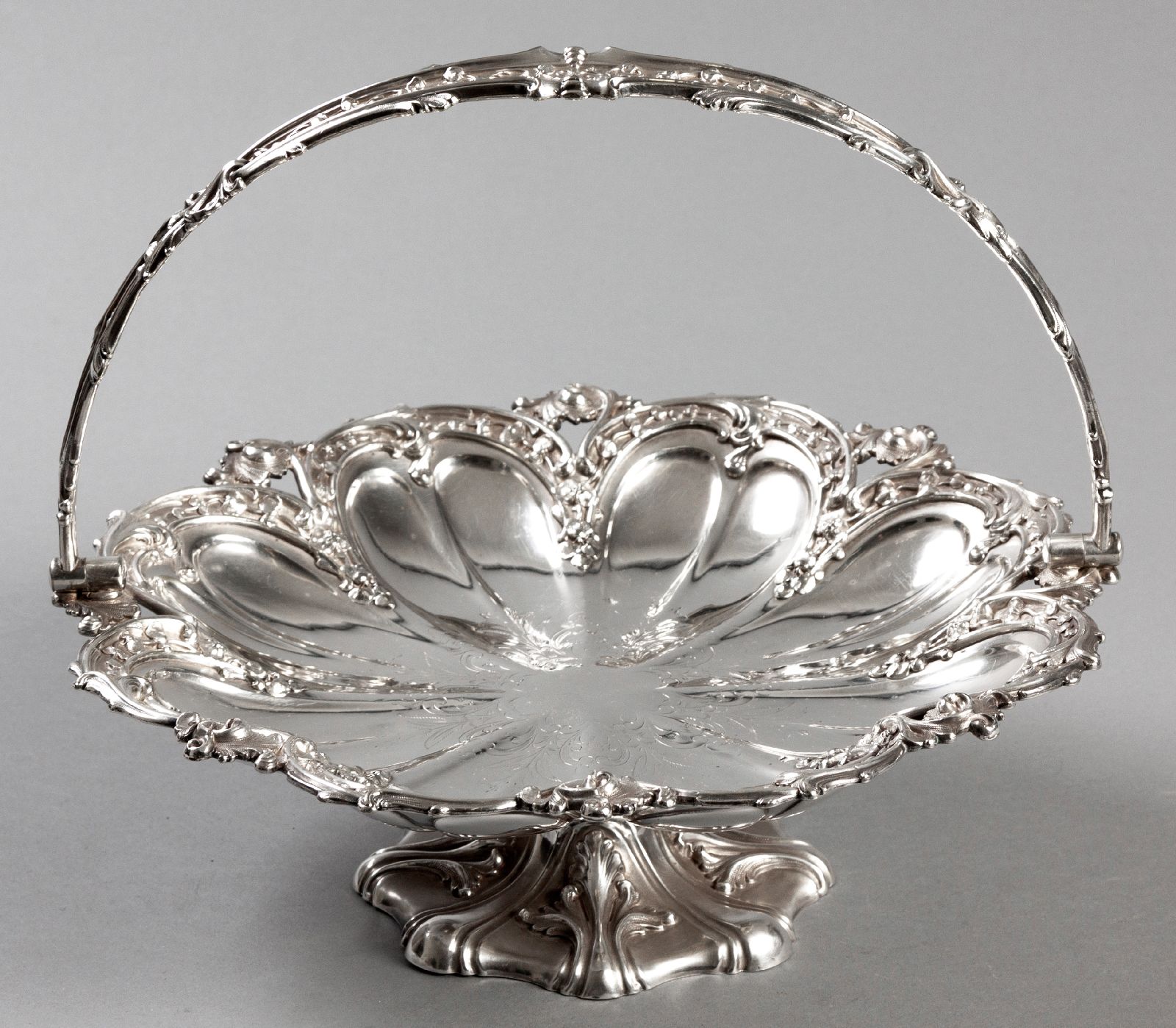 A SILVERPLATE BASKET, the swing-over handle decorated with embossed scrolls, fruit and applied