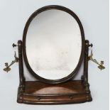 A VICTORIAN MAHOGANY DRESSING MIRROR, the oval plate flanked by carved scrolled pillars with brass