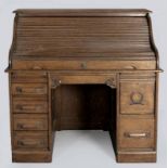A LATE 19th CENTURY AMERICAN OAK ROLL-TOP BUREAU, the tambour shutter opening to reveal a writing