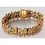 A 9ct YELLOW GOLD BRACELET, composed of segmented organic bars, with tongue clasp and two figure