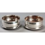 A PAIR OF CONTINENTAL .925 STD SILVER BOTTLE COASTERS, with fold-over rims, wooden bases, one with a