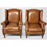 A PAIR OF LEATHER UPHOLSTERED WINGBACK ARMCHAIRS OF CLASSICAL-STYLE, featuring close brass nailing