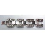 A VINTAGE SILVER BRACELET, composed of eleven inter-locking bars, the outer bars decorated with