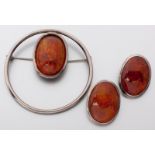 A SILVER AND AMBER BROOCH, BY COBRA & BELLAMY, SLOAN ST., LONDON, the oval tube-set cabochon amber