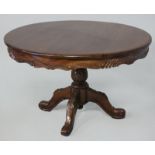 A VICTORIAN-STYLE CIRCULAR DINING TABLE, the moulded top with carved frieze, standing on a carved