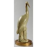 A CHINESE CELADON GLAZED FIGURE OF A HERON, 19th CENTURY, standing on a rock, mounted on a gilded