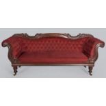 AN EARLY VICTORIAN MAHOGANY SOFA, the carved back top-rail above deep button upholstered seat with